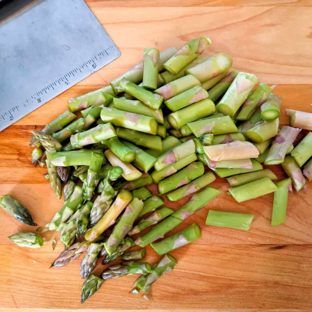 overhead photo of chopped asparagus on a cutting board