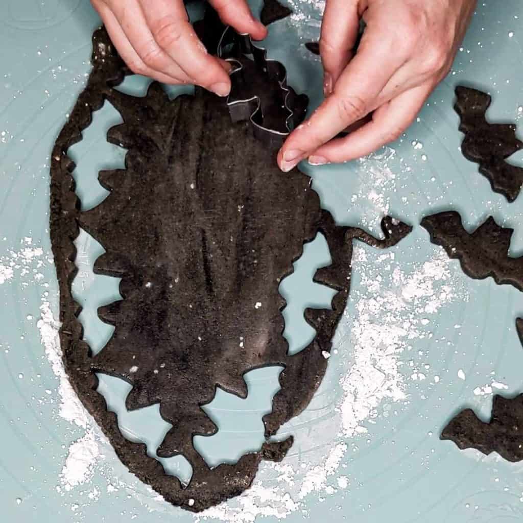 photo of black marzipan bats being shaped with a cookie cutter