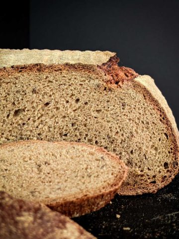 Side view photo of a sliced loaf of caraway rye bread