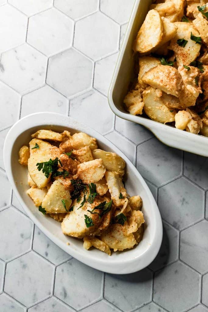 Overhead photo of a serving dish and an individual portion of hot german potato salad