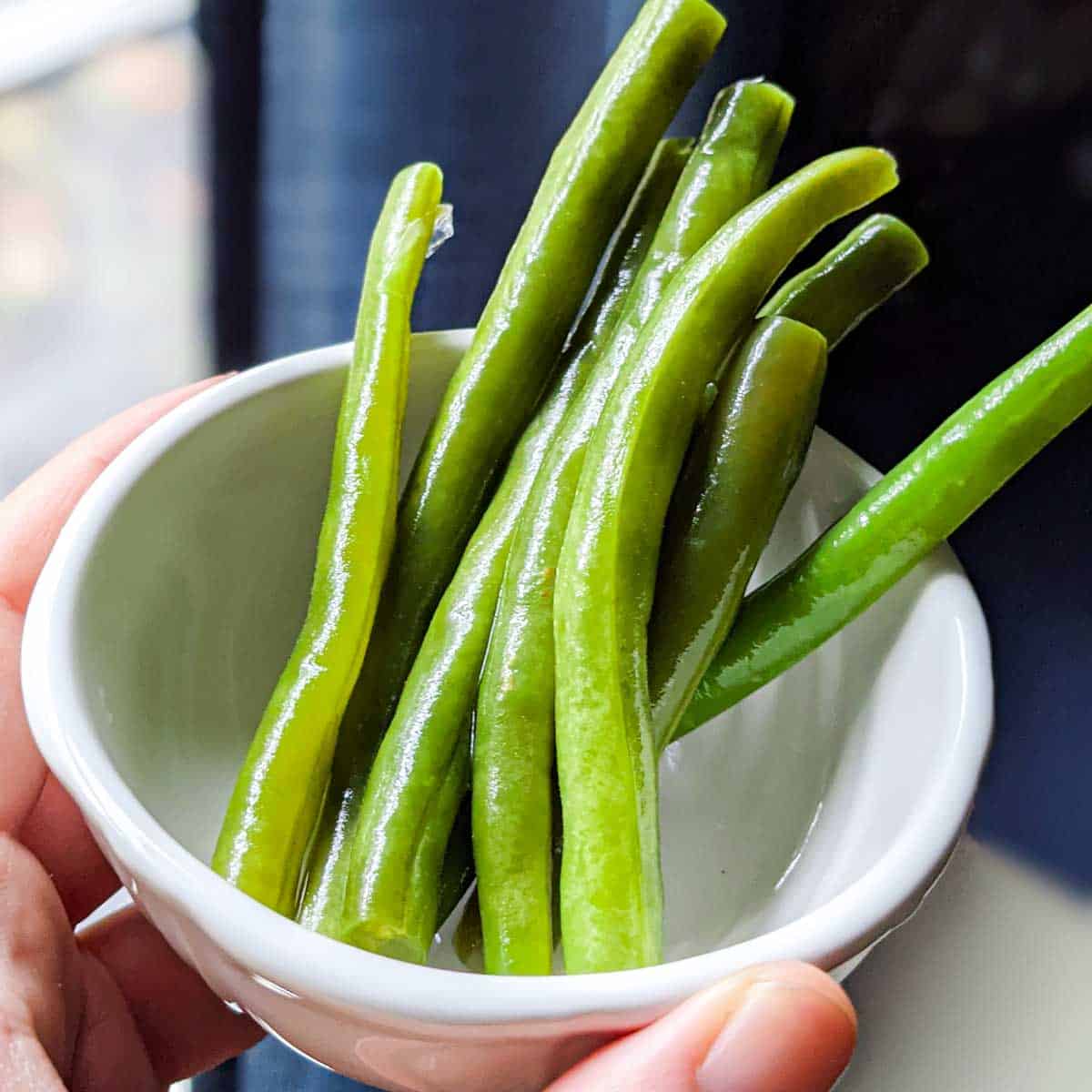 photo of lacto-fermented green beans in a small white bowl