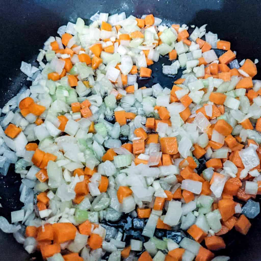 photo of carrots, celery, garlic, and onions being sauteed in a pot for split pea soup