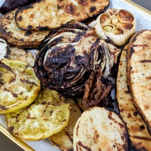 Photo of a platter of grilled vegetables: radicchio, kohlrabi, potatoes, garlic, and green tomatoes