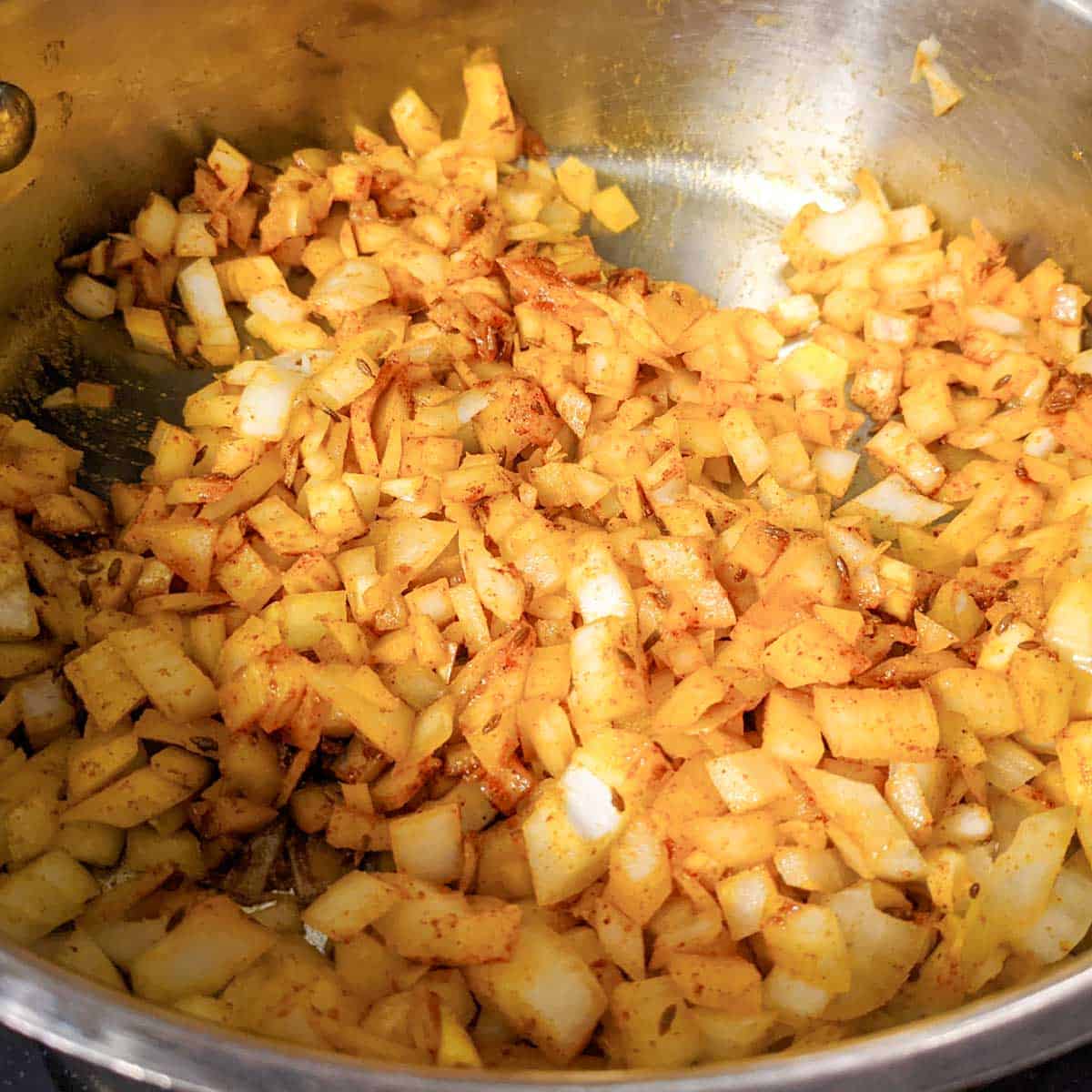 Overhead photo of a pan with chopped onions and spices